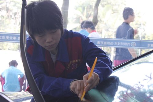 刘崇如同学正在认真地给汽车贴膜