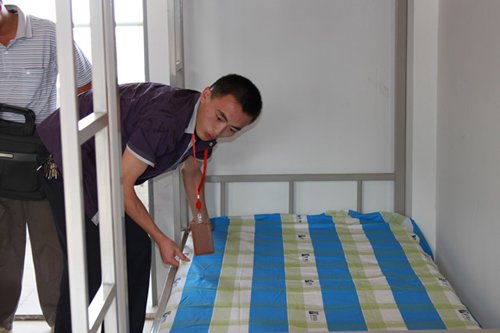 徐涛老师正在帮同学整理床铺 