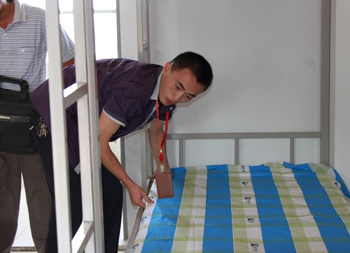 班主任正在帮学生整理床铺